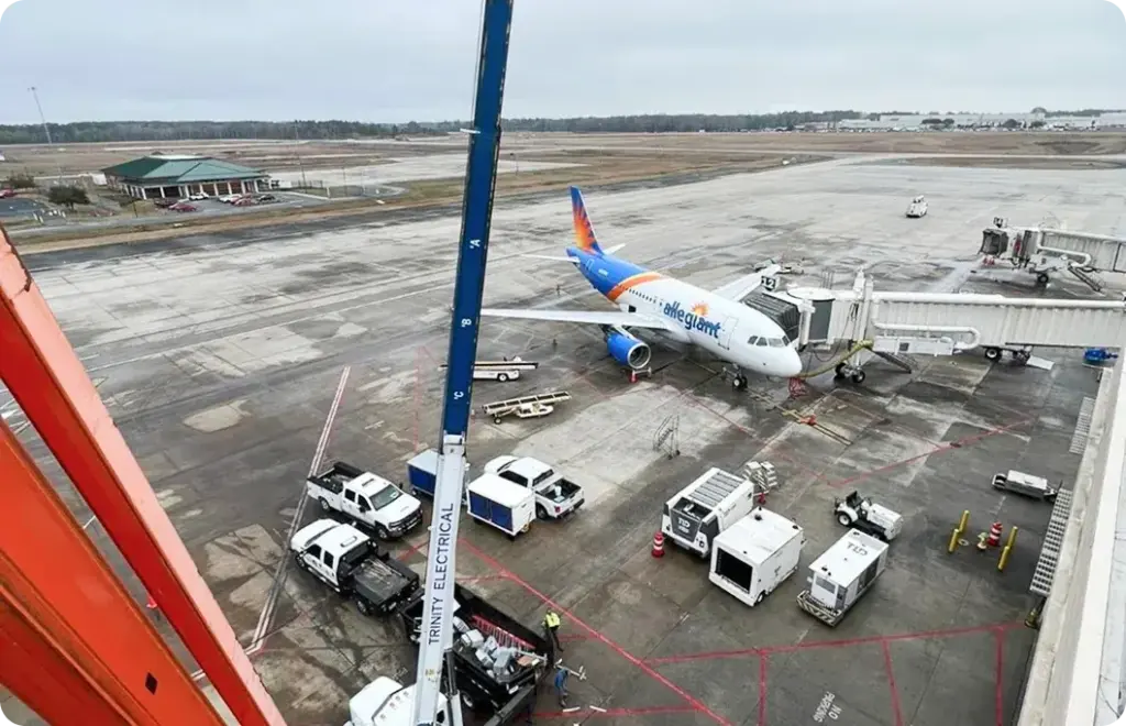 An airplane sits on the tarmac connected to the jet bridge