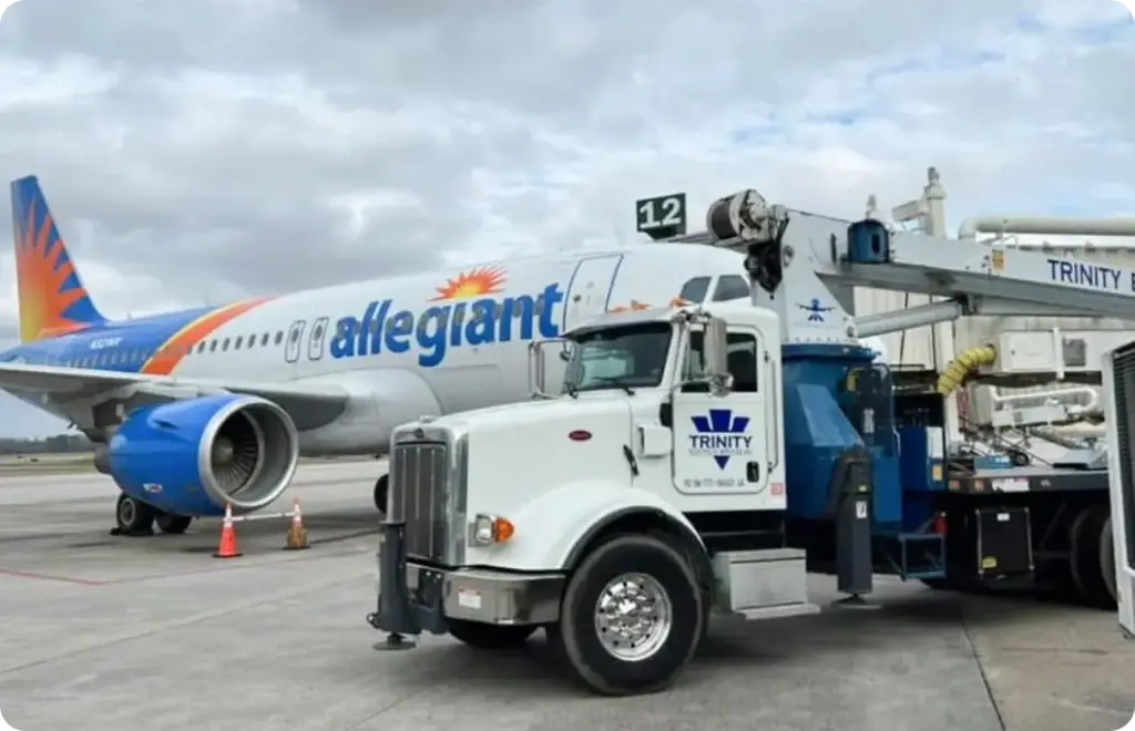 A Trinity Electrical Services on site of airport property next to an Allegiant airplane